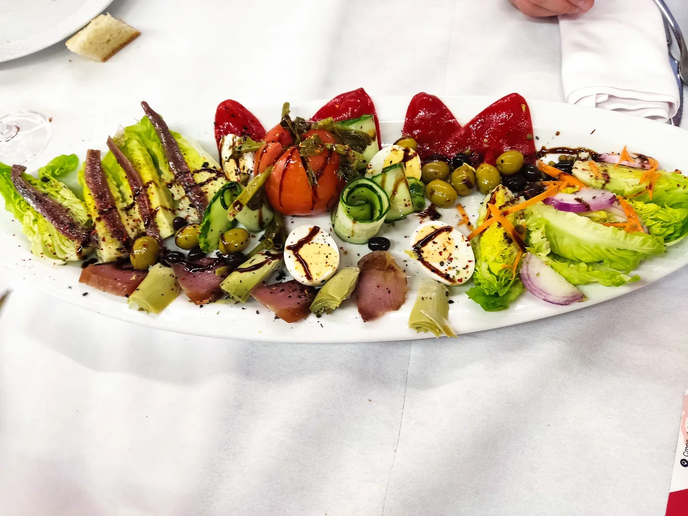 Ensalada con anchoas, tomate, pimiento asado y aceitunas